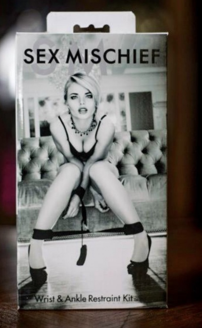 Embalagem de Kit de Algemas para Punhos e Tornozelos com imagem de mulher e texto SEX & MISCHIEF