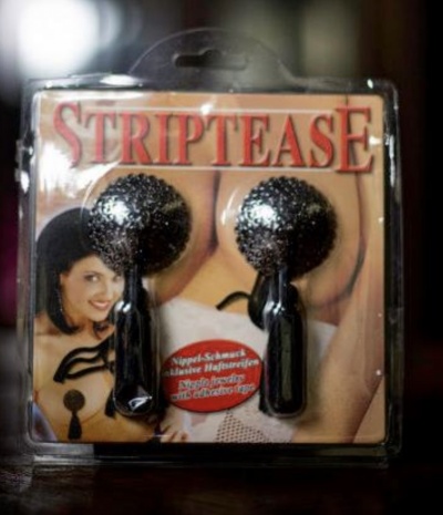 Embalagem plástica com tampões de silicone pretos e texto STRIPTEASE