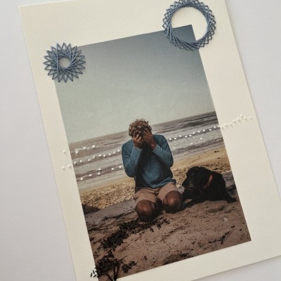 Fotografia numa moldura branca decorada com apliques azuis, pérolas e desenho preto