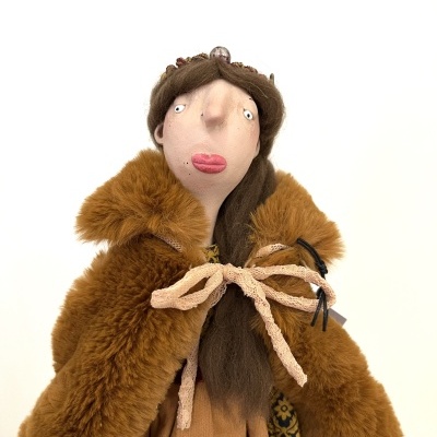 Boneca de tecido com roupa castanha e coroa