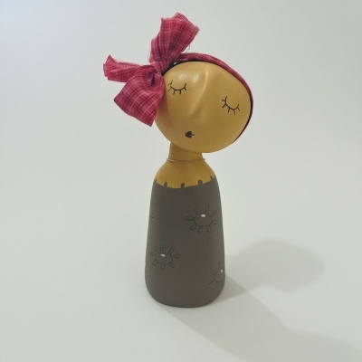 Boneco decorativo amarelo com lenço vermelho e vestido cinzento com flores