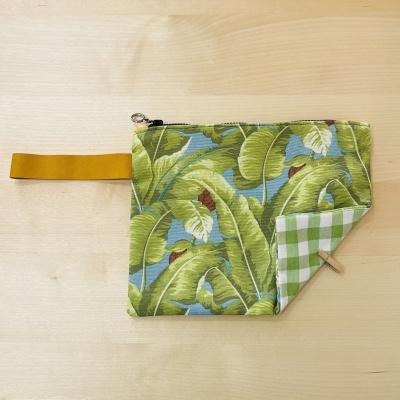 Bolsa pequena com padrão de folhas e xadrez verde