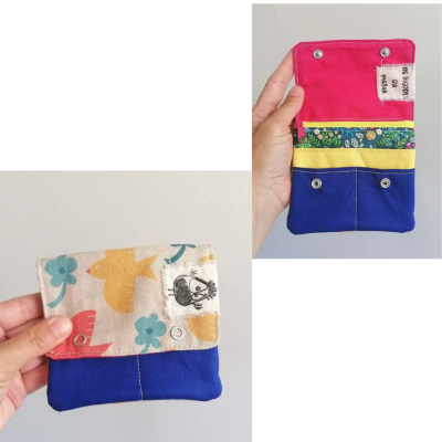 Carteira pequena colorida em tecido com padrões florais e botão de pressão
