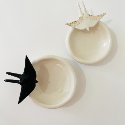 Dois pratos de cerâmica brancos com andorinhas decorativas preta e branca