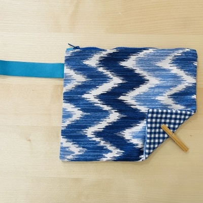 Bolsa quadrada azul e branca com padrão zig-zag e interior xadrez