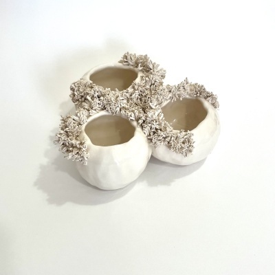 Conjunto de três vasos cerâmicos brancos com detalhes florais