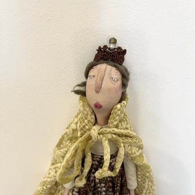 Boneca decorativa de tecido com capa amarela rendada e coroa castanha