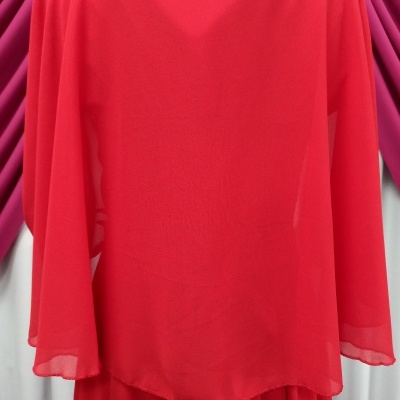 Blusa vermelha de tecido leve com mangas largas e fundo de cortinas magenta e branco