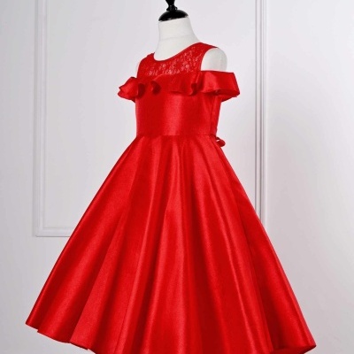 Vestido infantil vermelho com babados e renda num manequim branco