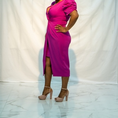 Mulher com vestido rosa choque midi de manga bufante e sapatos altos bege