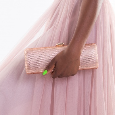 Mala rosa dourada trançada com mão segurando e vestido rosa de tule