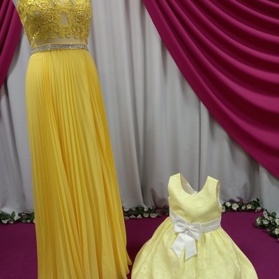 Vestidos amarelos com detalhes em renda e laço em manequins