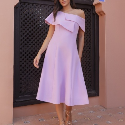 Vestido lilás ombro só com sandálias douradas em cenário com porta preta e chão de azulejos