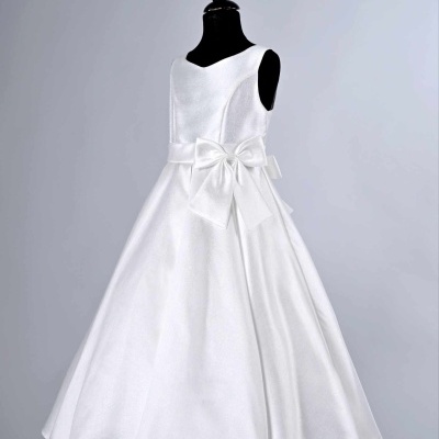 Vestido branco para criança com laço num manequim preto