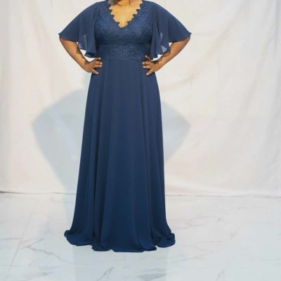 Vestido comprido azul escuro com corpo em renda e mangas curtas largas.