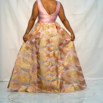 Vestido de festa rosa com saia dourada brilhante visto de costas