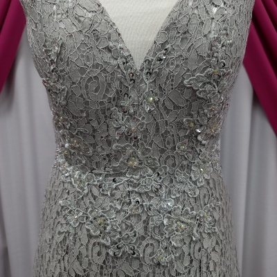 Vestido cinzento em renda floral com brilhantes e decote em V sobre manequim branco