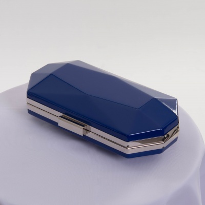 Estojo rígido azul octogonal com detalhes prateados num fundo branco