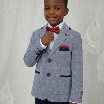 Criança com fato azul claro, gravata borboleta vermelha e lenço de bolso vermelho