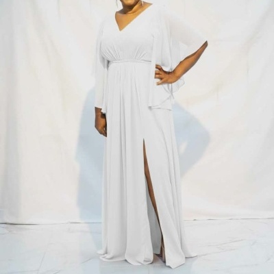 Mulher sorridente a usar vestido longo branco com manga transparente e fenda na perna