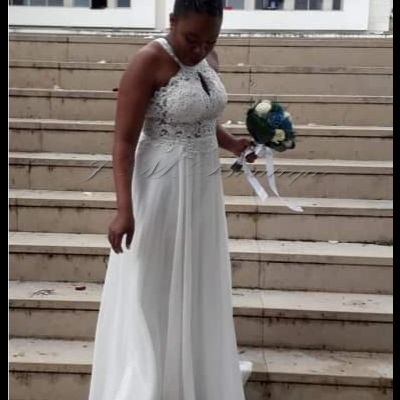 Mulher com vestido branco longo e bouquet numa escadaria