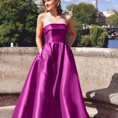 Mulher vestindo vestido longo magenta sem alças em paisagem urbana com monumentos