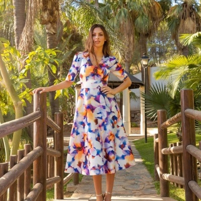Mulher com vestido midi floral em ponte de madeira ao ar livre