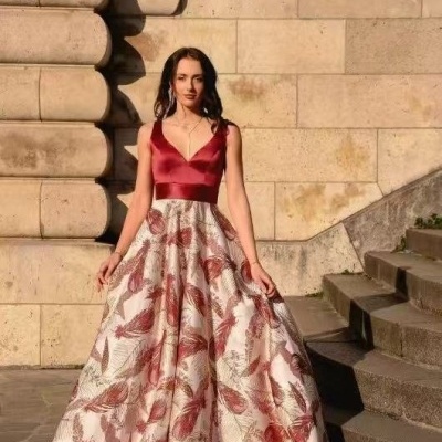 Vestido longo com corpete vermelho em cetim e saia estampada com folhagem em tons vermelhos e beges