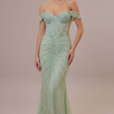 Vestido de festa longo verde claro com detalhes brilhantes e ombros descobertos.