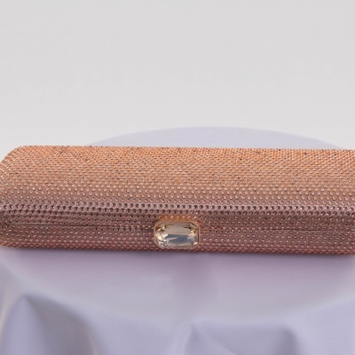 Carteira de mão rosa decorada com pedras pequenas e fecho com pedra transparente