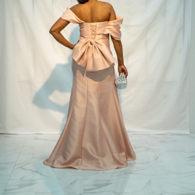 Vestido rosa claro acetinado com laço grande nas costas e corset, visto de costas, mulher em chão branco de mármore