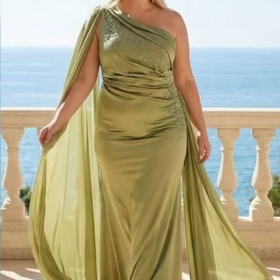 Vestido longo verde-oliva com um ombro só e capa fluida da mulher ao ar livre com vista mar