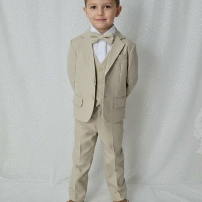 Menino com fato bege, camisa branca e gravata borboleta