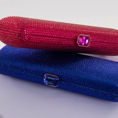 Dois porta-óculos brilhantes, um vermelho e um azul, com fechos de pedra colorida