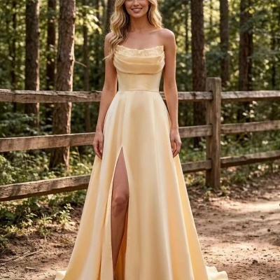 Vestido longo amarelo claro com renda e racha frontal, mulher loira em ambiente exterior com árvores.