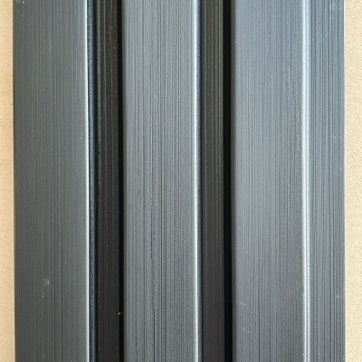Painel preto texturizado com quatro superfícies em relevo sobre fundo bege