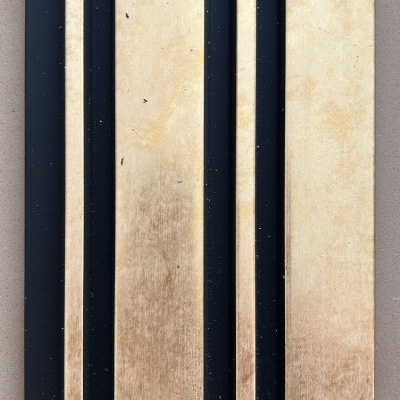 Painel decorativo em madeira clara e preto com listas verticais