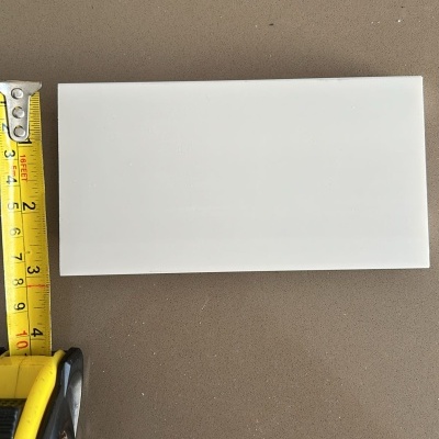 Placa branca retangular com fita métrica ao lado