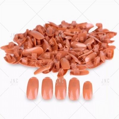 Unhas postiças cor salmão com acabamento brilhante e formato oval