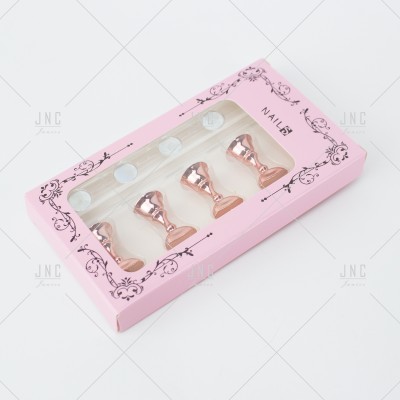 Conjunto de quatro carimbos para unhas em metal cor de rosa em embalagem rosa com janela