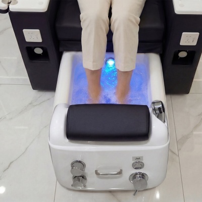 Banheira de hidromassagem branca com luz azul e almofada preta para pés