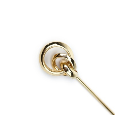 Alfinete dourado com dois anéis entrelaçados em fundo branco