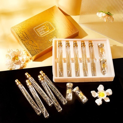 Conjunto de frascos de vidro com líquido dourado e embalagem dourada