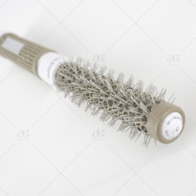 Escova de cabelo redonda cinzenta com cerdas brancas sobre fundo branco