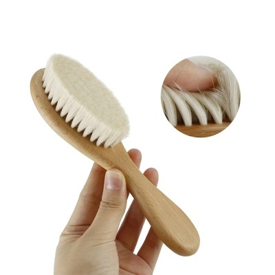 Escova de madeira com cerdas brancas macias e cabo ergonómico sobre fundo branco