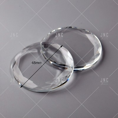 Dois cristais facetados transparentes com 45 mm de diâmetro sobre superfície cinzenta