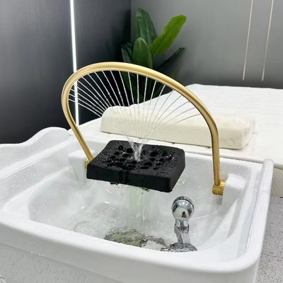 Fonte decorativa com jatos de água em cuba branca com estrutura dourada