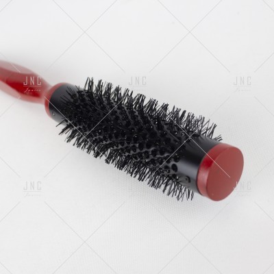 Escova de cabelo redonda preta e vermelha sobre fundo branco