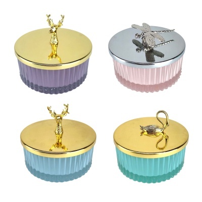 Frascos decorativos redondos de vidro com tampas metálicas decoradas com figuras animais.