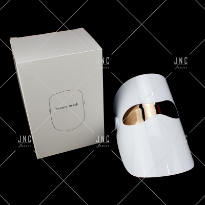 Máscara facial branca com visor dourado e embalagem branca